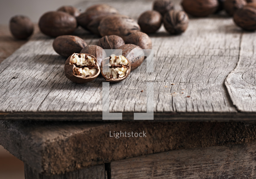 Pecans on a rustic plywood table.