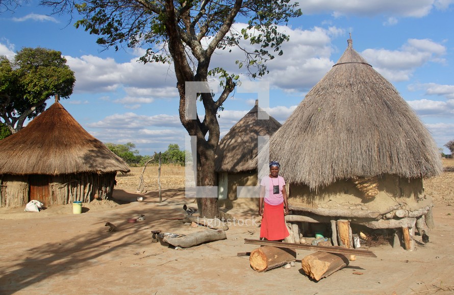a woman standing in an African village 