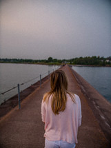 a woman walking on a jetty 