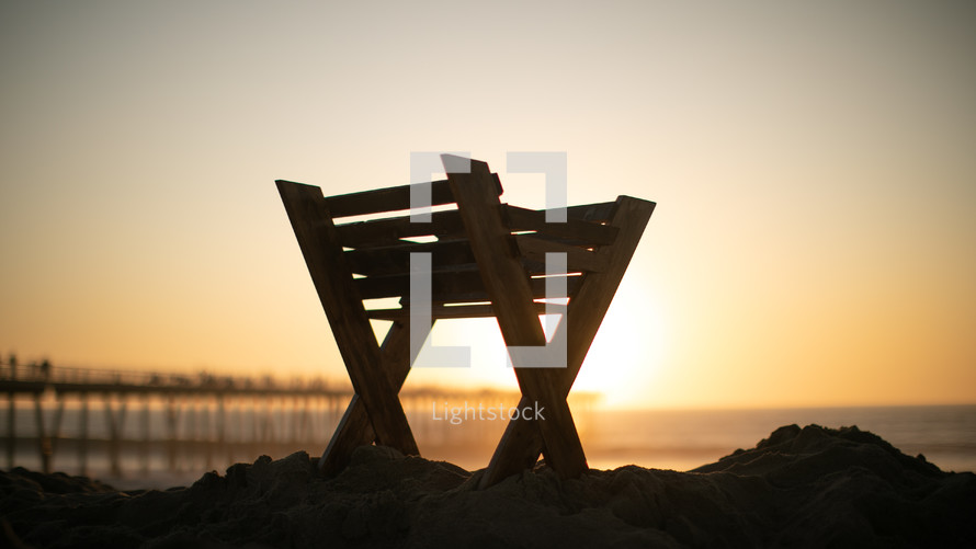 manger on a beach at sunset 