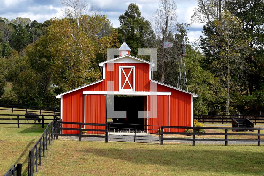 A red barn and fenced in farm land 