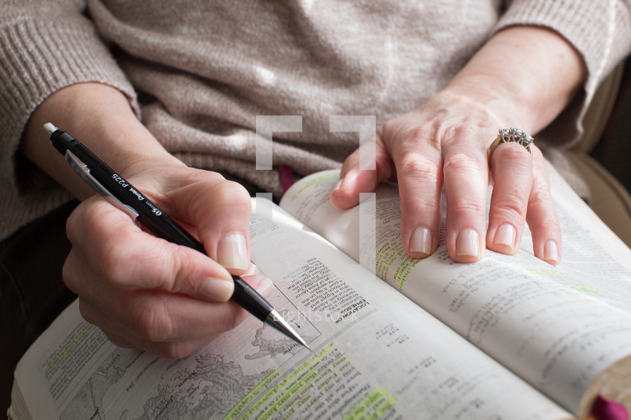 A woman highlighting a passage in the Bible.