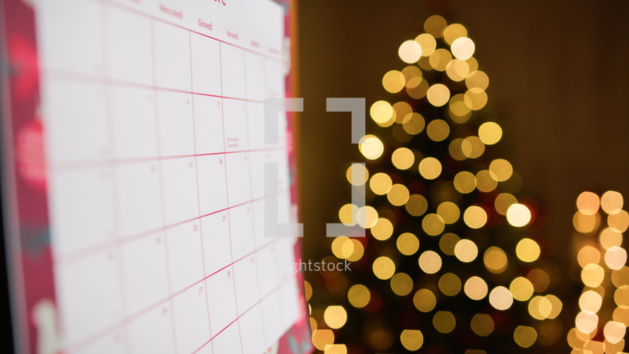 December calendar with blurred Christmas tree background