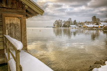 snow and ice on a boathouse on a lake in winter 