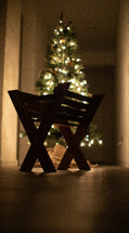 manger in front of a Christmas tree 