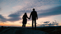 Couple Hold Hands And Watch The Sunset