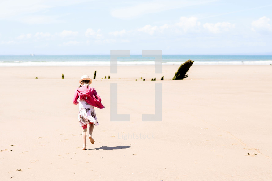 a girl running on a beach 