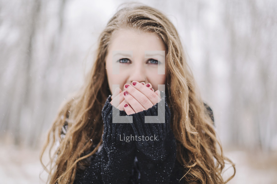 a girl outside warming her hands