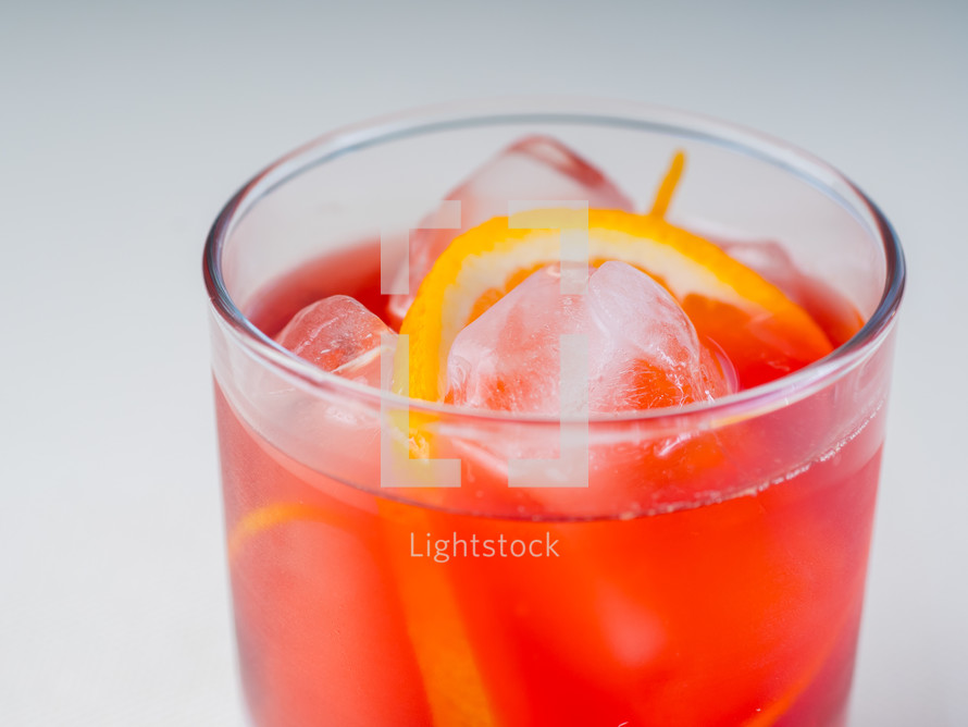 Colorful, bright, drink decorated with ice and fruit.