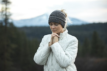 a woman praying on a mountain 