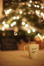 A mug with the words 'Silent Night' written on it - Christmas tree in the background