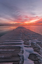 snow on a pier at sunset 