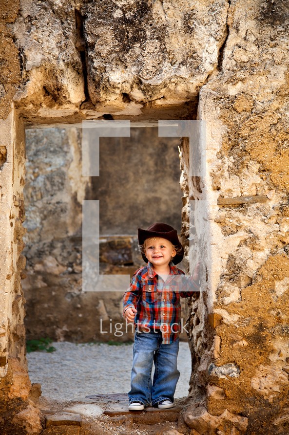 smiling toddler boy in a cowboy hat 
