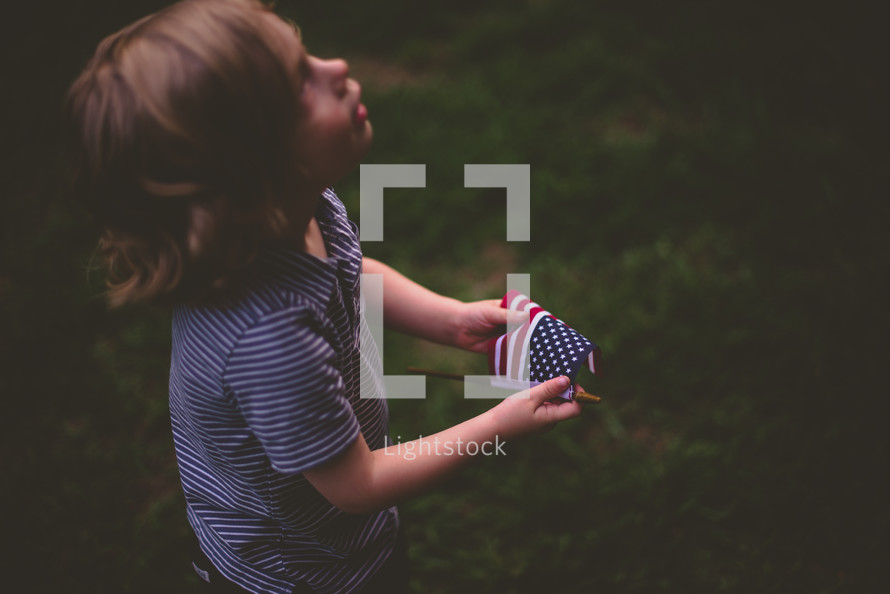 a toddler holding an American flag 