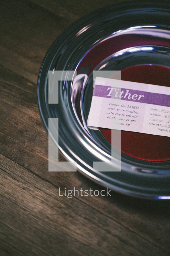 Tithing envelope resting inside an offering plate