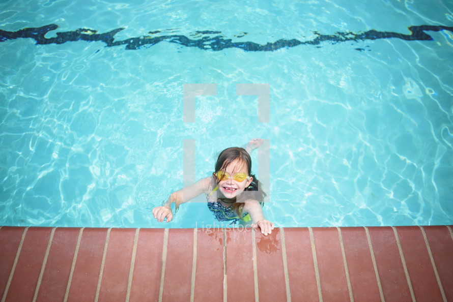 a girl child swimming in a pool 