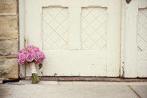 bouquet of pink roses resting by church doors