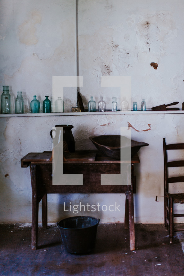 glass bottles on a shelf and an old table 