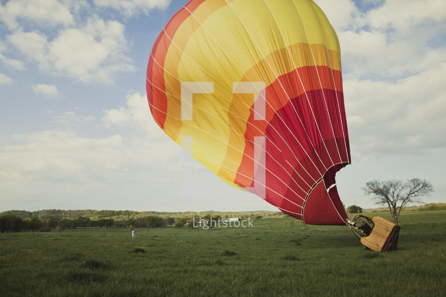 Hot air ballon taking off in a field 