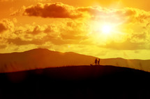 couple walking their dog at sunset 