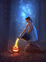 young girl pours light into pumpkins for halloween.