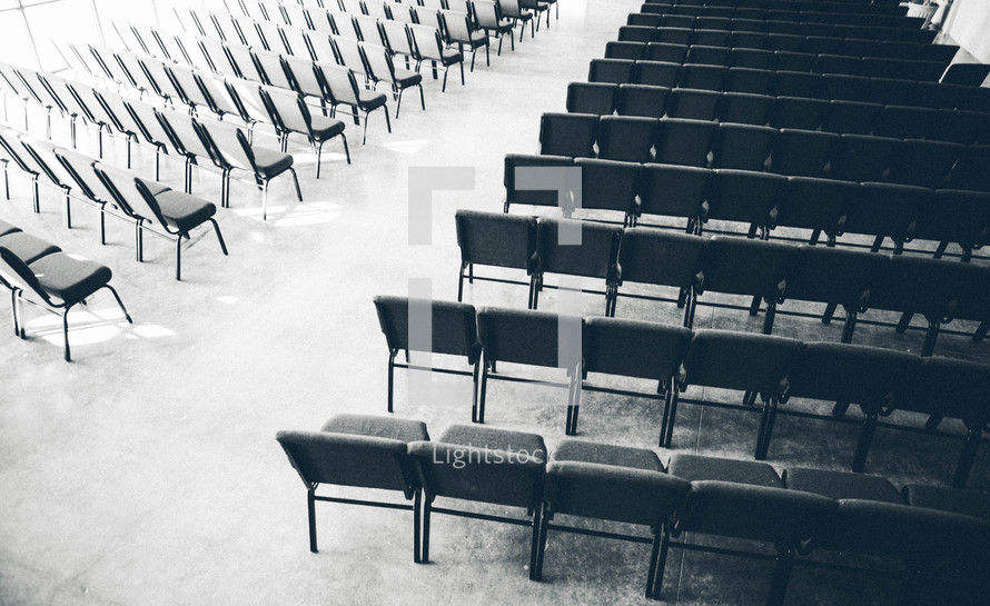 aisle between empty rows of chairs in a church