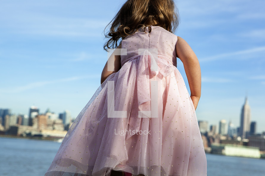 little girl in front of a city skyline 