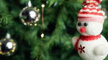 small snowman and balls decoration on a Christmas tree
