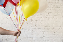 a man holding out balloons 