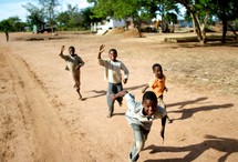children chasing after a moving vehicle 