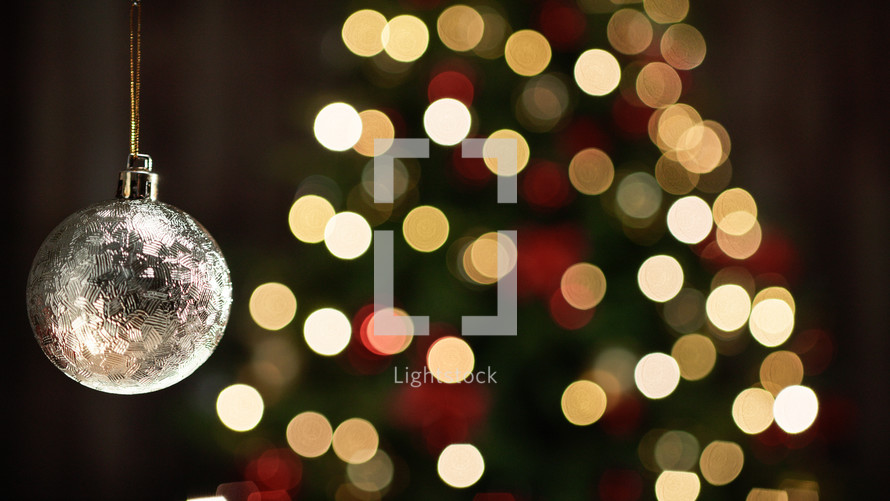 Golden Christmas Ball on blurred tree copy space background
