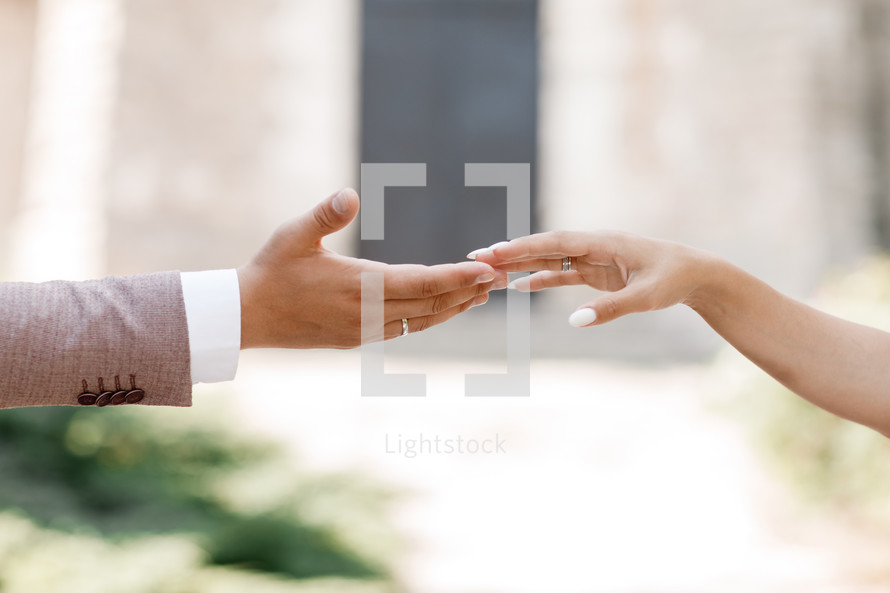 touch of hands. Young married couple holding hands, ceremony wedding day. hand of the groom and the bride, guys and girls, outdoors.