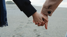 Man and woman holding hands on the beach