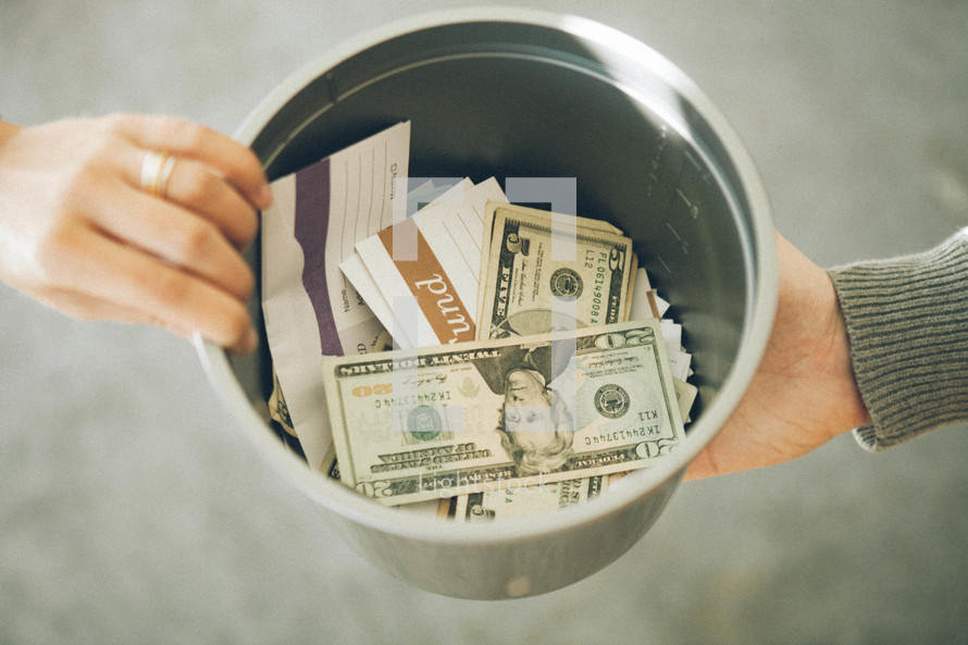 Tithes and offering inside a bucket being passed