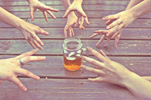 everyone reaching for one glass