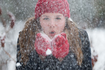 woman blowing snow outdoors 