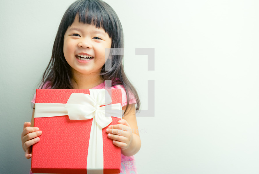 happy girl holding a wrapped gift 