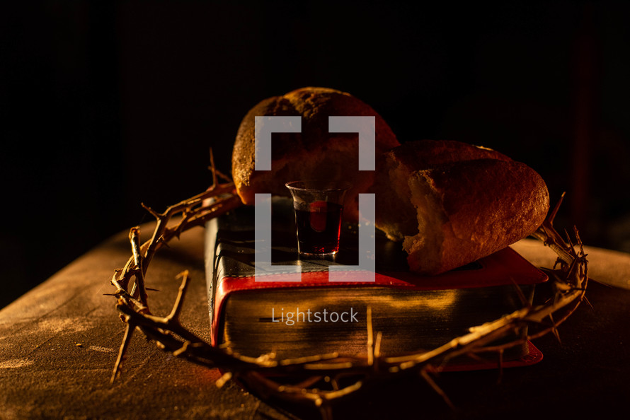 crown of thorns, bread, and communion cup on a Bible 