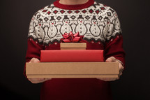 a man holding a stack of Christmas gifts 
