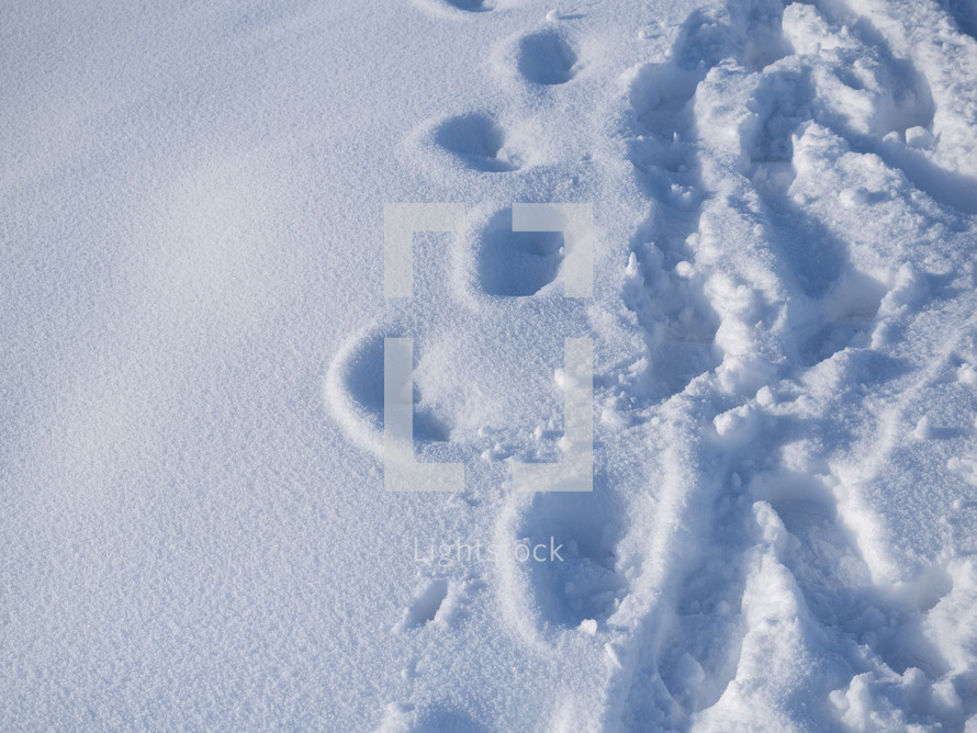 Outdoor footprints on white snow in winter season. Footprints on mountain hike path track