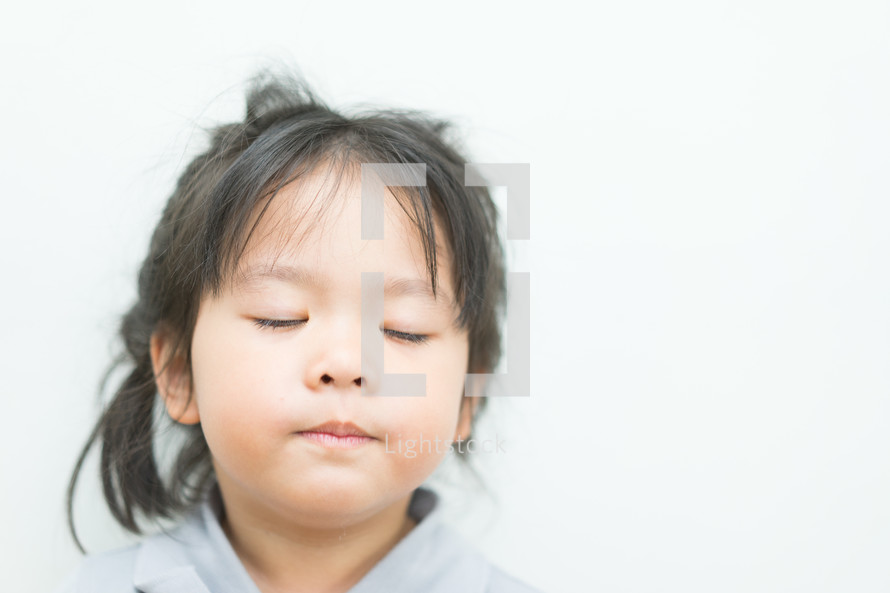 a toddler girl with closed eyes 