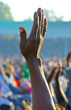 A black hand is raised in worship