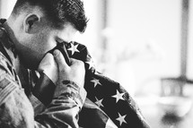 soldier crying into an American flag 