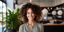Portrait of smiling young businesswoman with curly hair in coffee shop