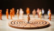 Miniature people : Businessman standing on dart board with target. Leadership and management concept.