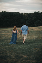 a couple holding hands walking outdoors 