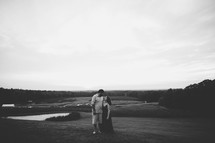 a couple hugging outdoors in black and white 