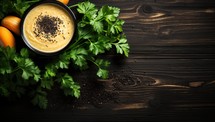 Pumpkin cream soup with black pepper and fresh parsley on wooden background