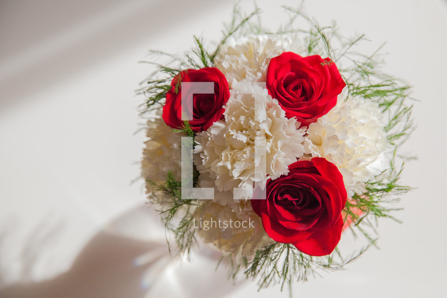 red roses and white carnations in a vase 