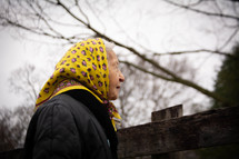 elderly woman with a handkerchief over her hair 